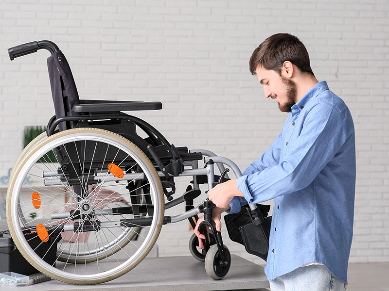man fixing wheelchair